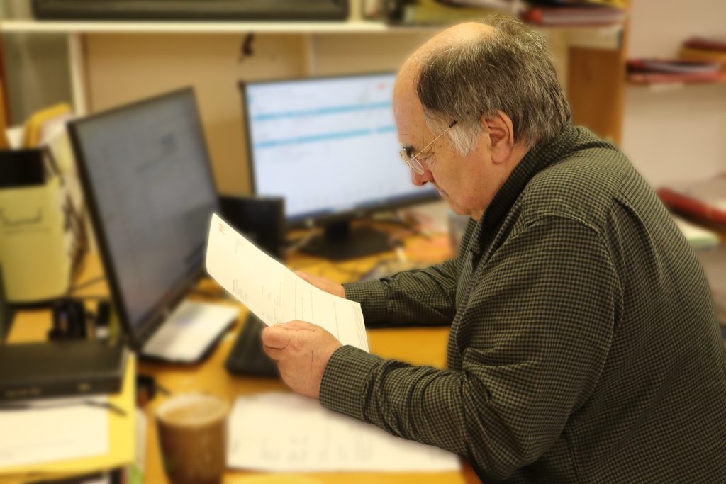 Employee studying a document in front of his computer